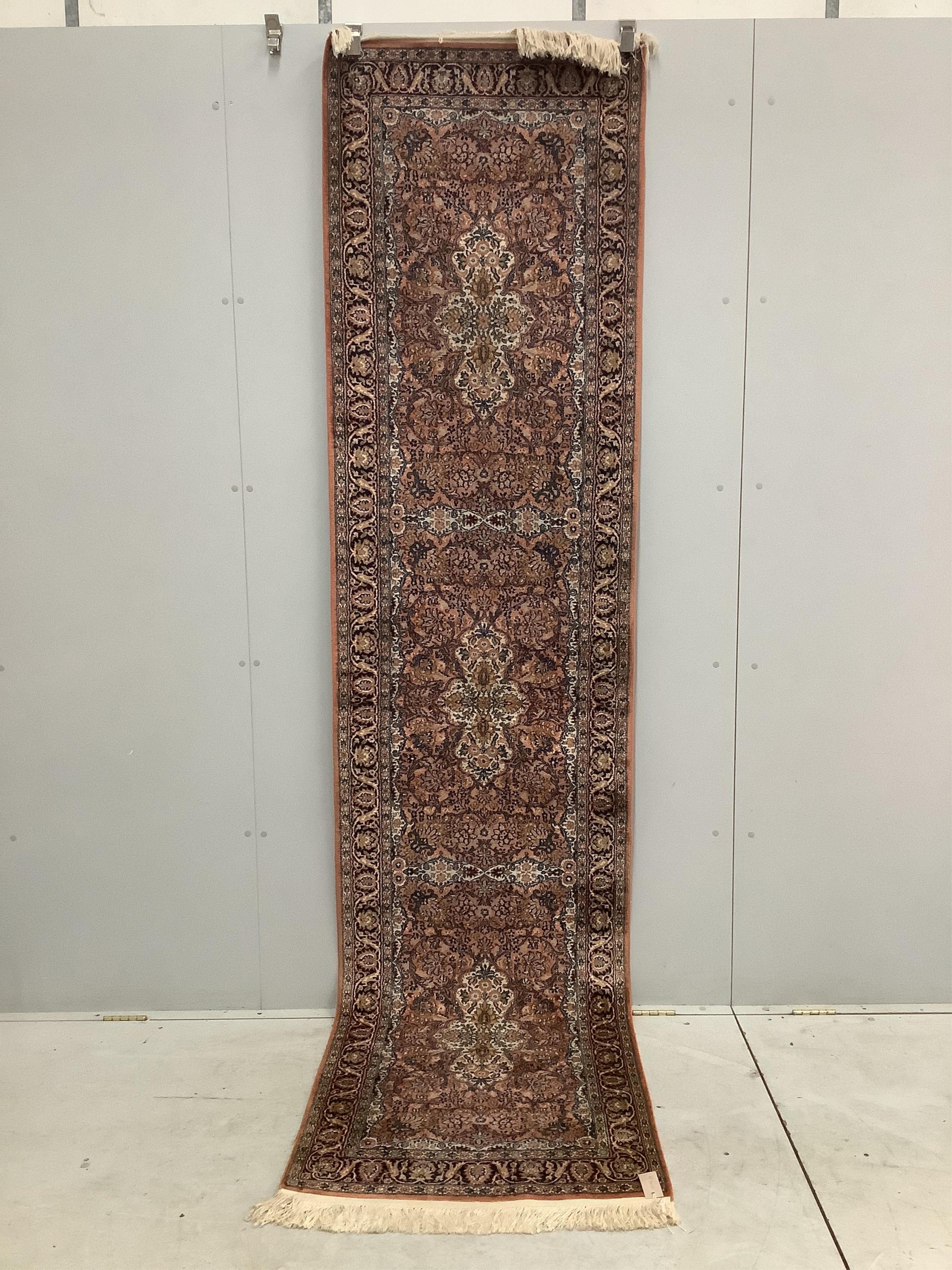 An Indian Persian style brick red ground runner, 390 x 77cm. Condition - good